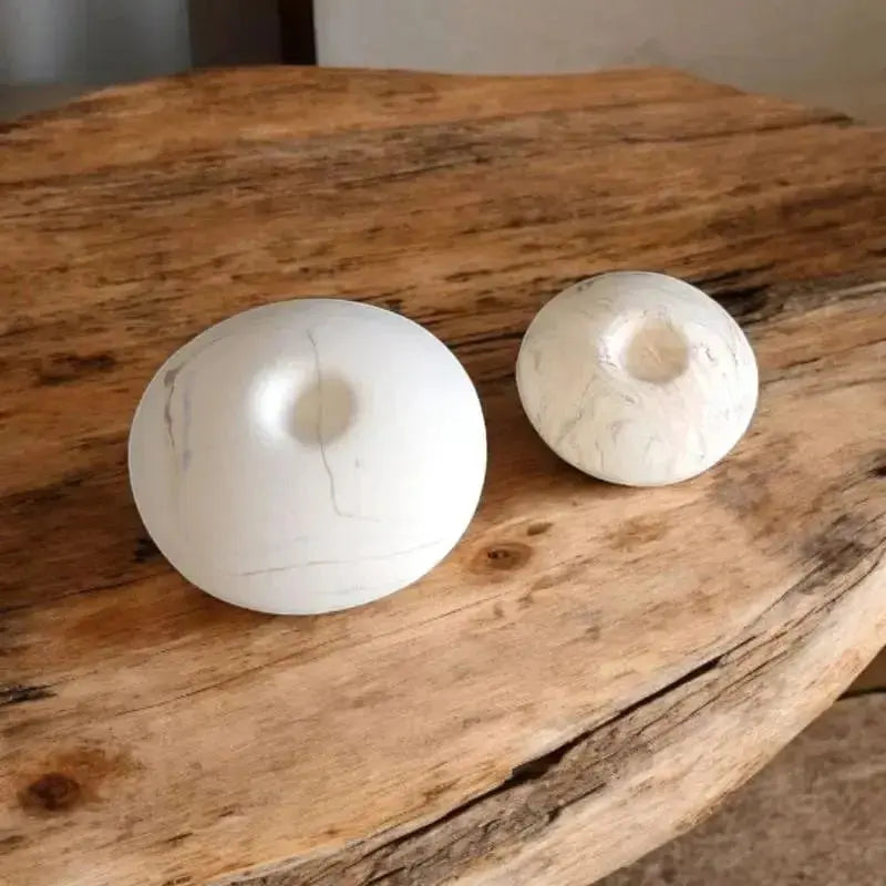 Un grand aroma et un petit aroma posée sur une table en bois