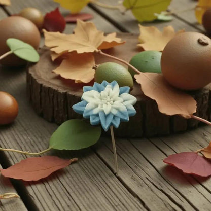 Étoile de Noël turquoise et blanche en cire artisanale, fleur décorative posée sur une table d’automne – Lulu Baladine