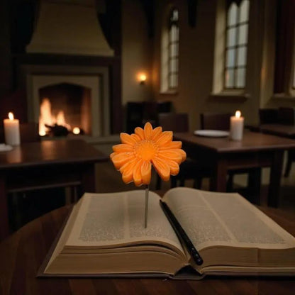 Gerbera orange en cire artisanale, fleur décorative artisanale posée sur un livre près d’une cheminée – Lulu Baladine