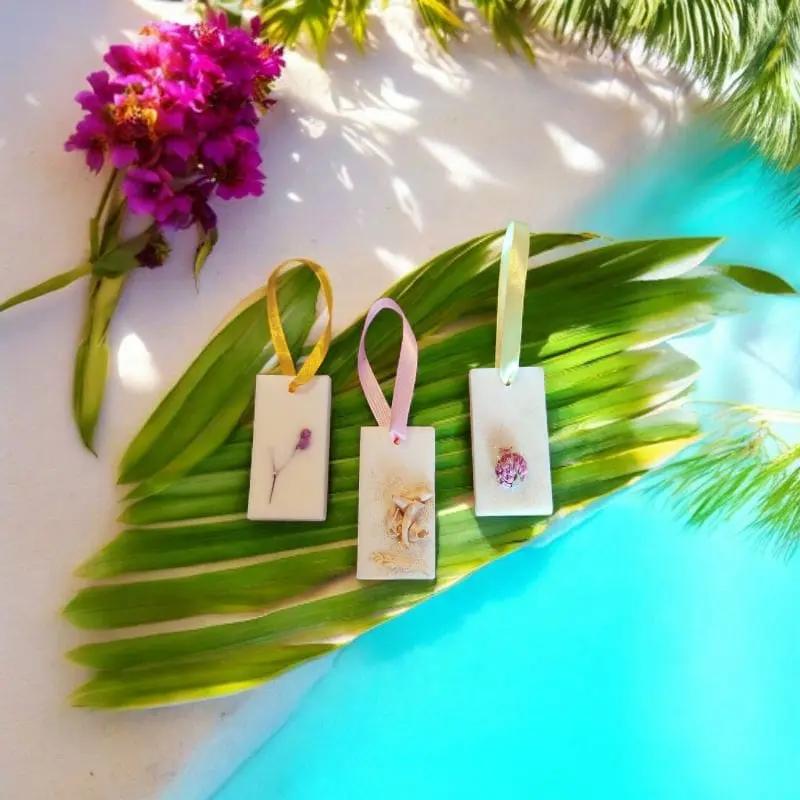Plaque Parfumé au parfum de votre choix, avec une fleur sèche coulé dans la cire végétal, la plaque est posé sur une feuille de bananier a l'arrière plan paradisiaque  